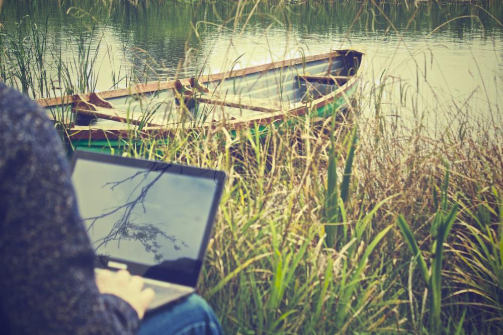Man on Laptop with Boat Man on Laptop with Boat