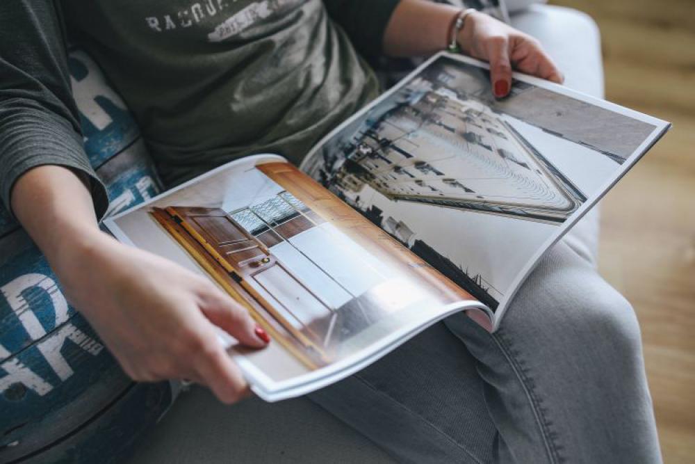 Woman reading a designer magazine on a couch Woman reading a designer magazine on a couch