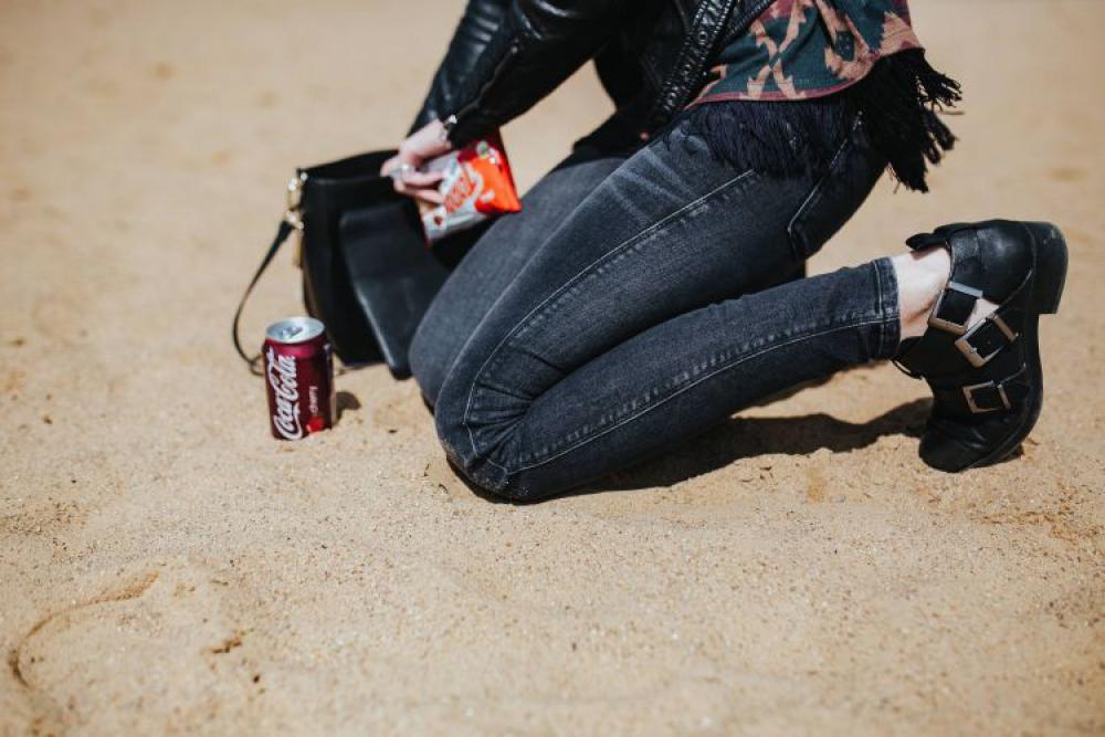 Young woman wearing a leather jacket and sunglasses on the beach Young woman wearing a leather jacket and sunglasses on the beach