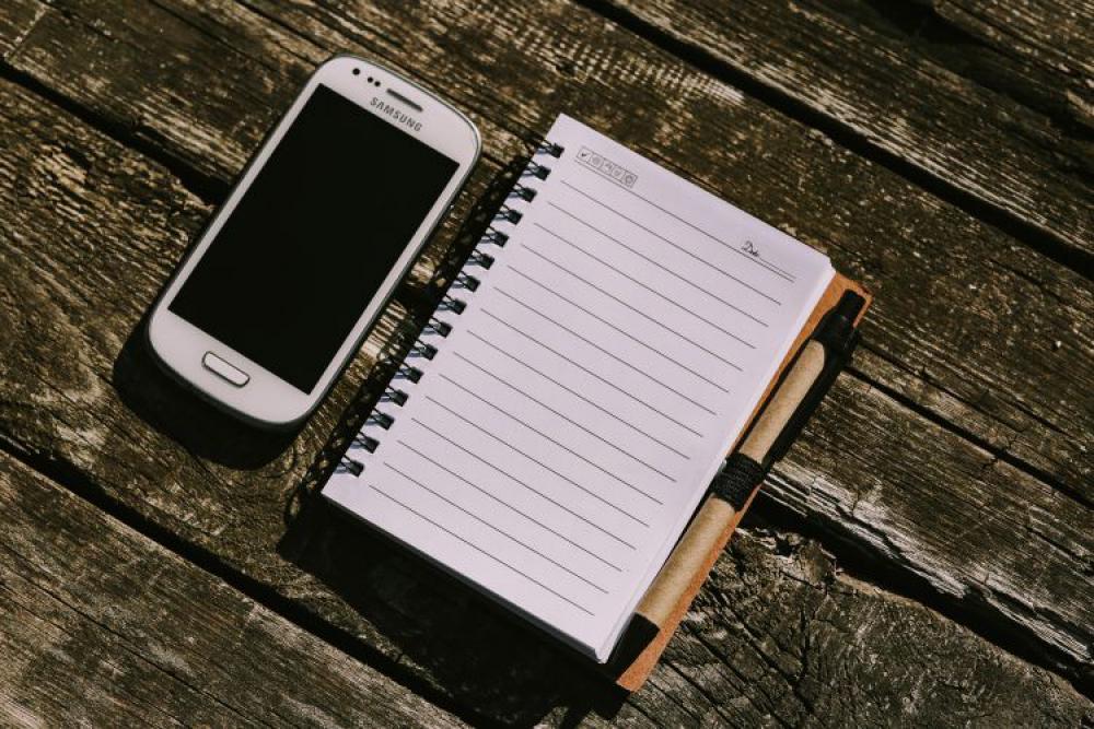 White smartphone with various items on a wooden background White smartphone with various items on a wooden background