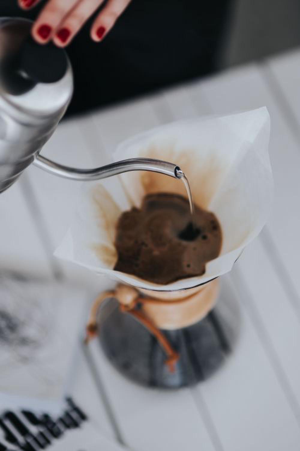 Woman pouring water in Chemex filter coffee maker Woman pouring water in Chemex filter coffee maker