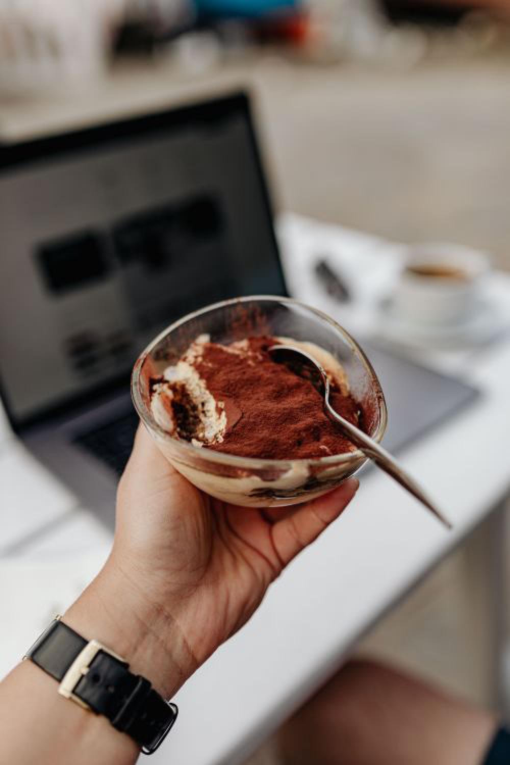 Working with a laptop by the sea. Cup of coffee and delicious tiramisu, Marina di Puolo, Italy Working with a laptop by the sea. Cup of coffee and delicious tiramisu, Marina di Puolo, Italy