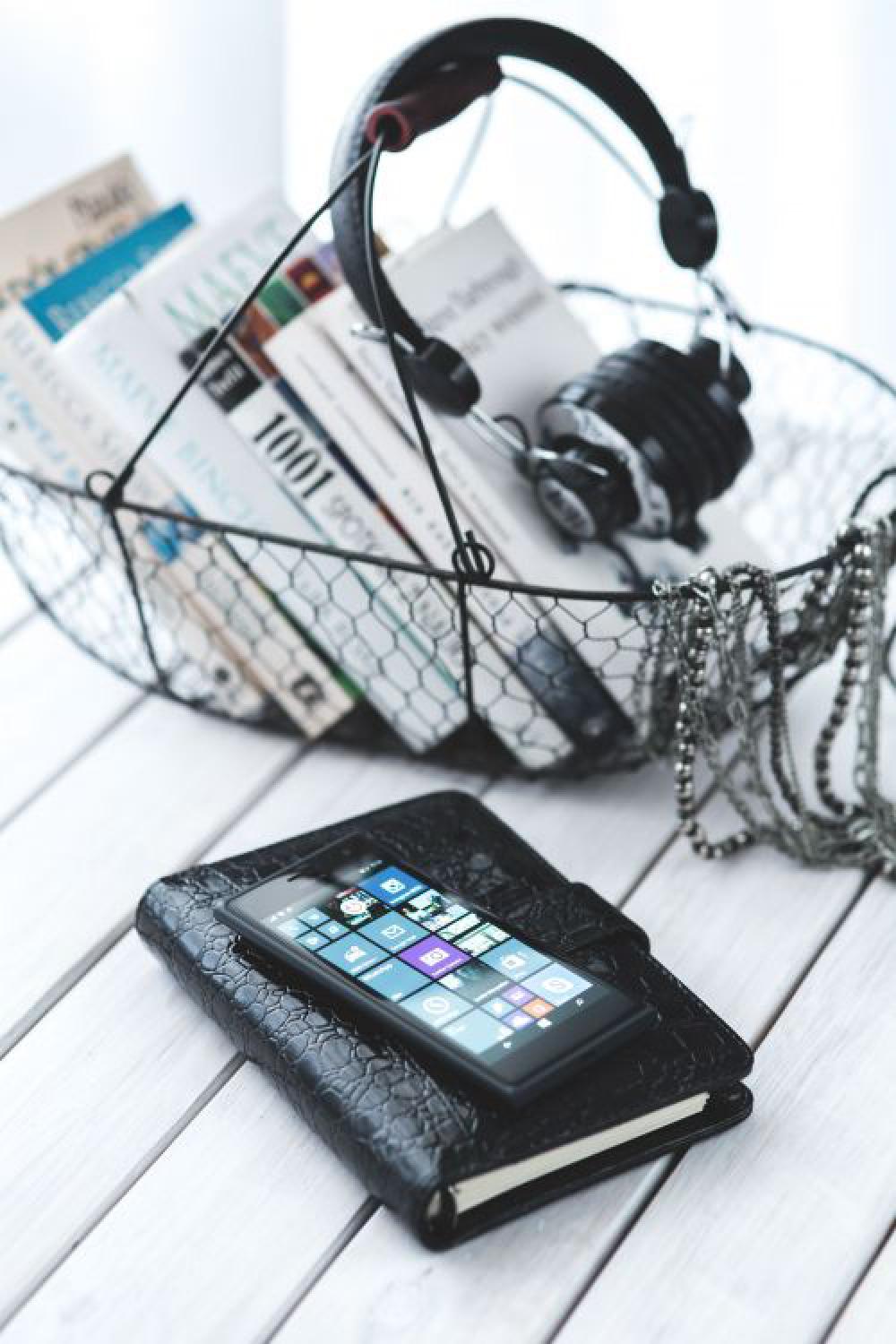 Black smartphone and headphones with various items Black smartphone and headphones with various items