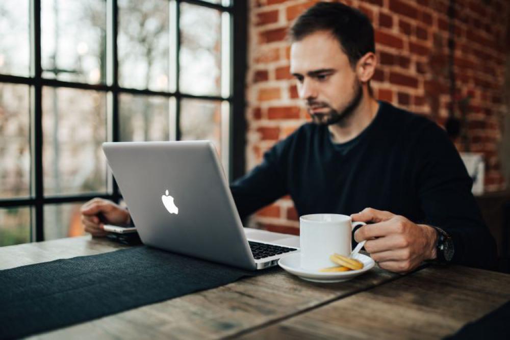 Young Entrepreneur Working from a Modern Cafe Young Entrepreneur Working from a Modern Cafe