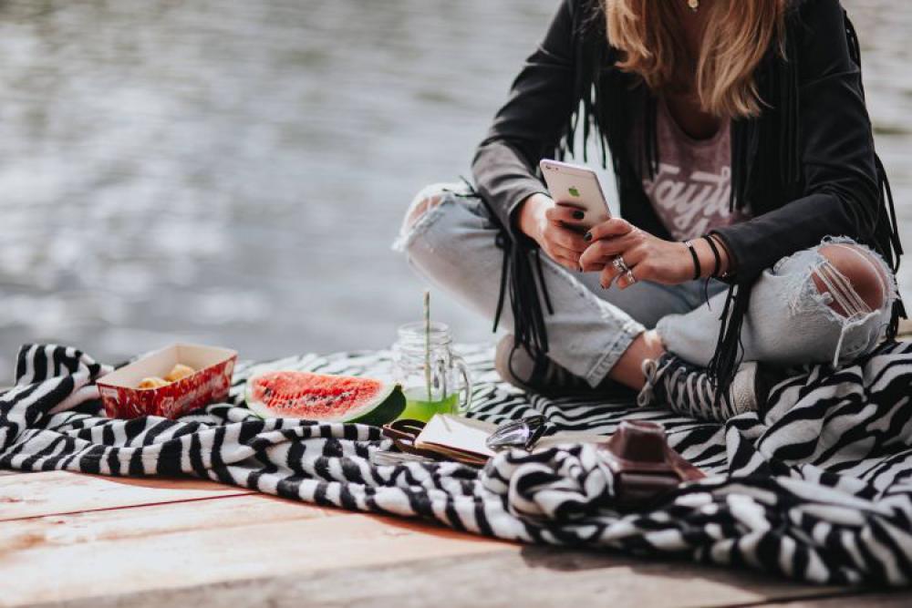 Blonde woman having a healthy snack at the wooden pier Blonde woman having a healthy snack at the wooden pier
