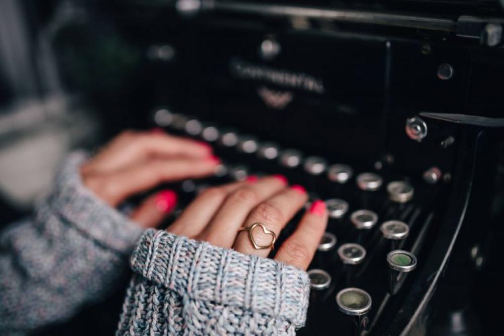 Woman typing on an old typewriter Woman typing on an old typewriter