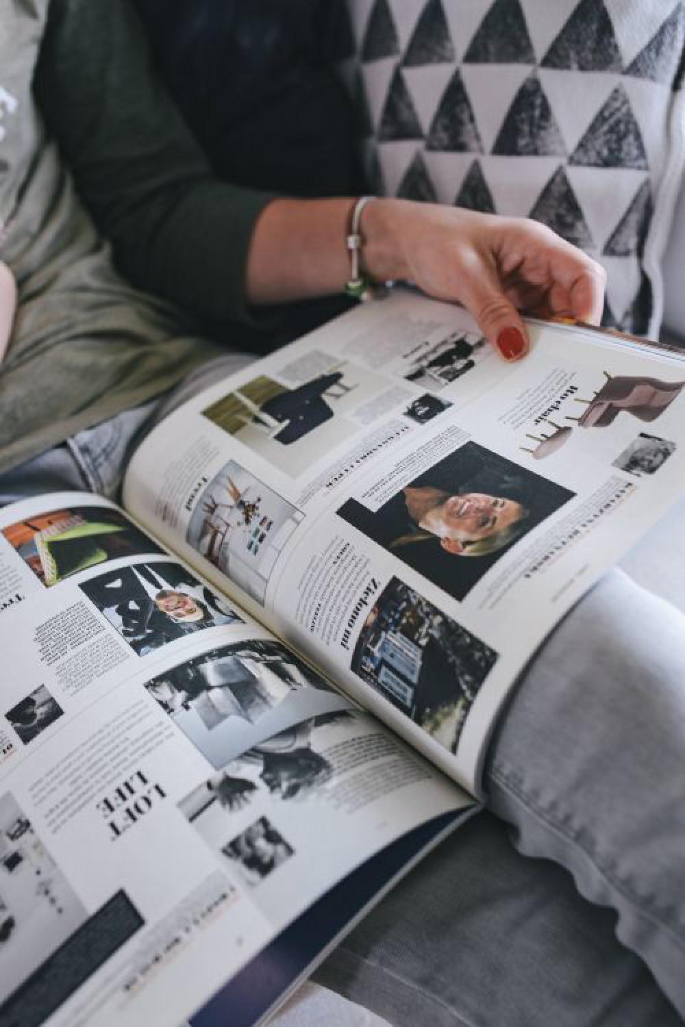 Woman reading a designer magazine on a couch Woman reading a designer magazine on a couch