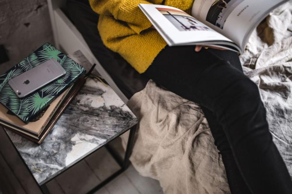 Young woman reading a magazine in bed Young woman reading a magazine in bed
