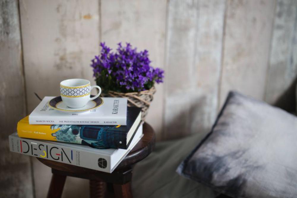 Books and purple flowers on a wooden stool by the bed Books and purple flowers on a wooden stool by the bed