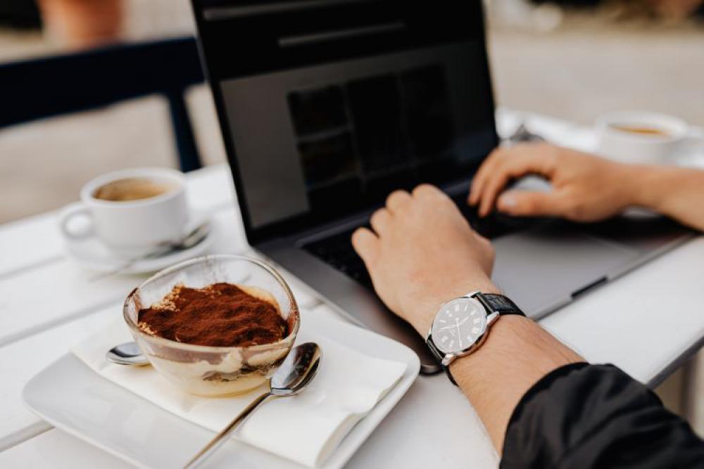 Working with a laptop by the sea. Cup of coffee and delicious tiramisu, Marina di Puolo, Italy Working with a laptop by the sea. Cup of coffee and delicious tiramisu, Marina di Puolo, Italy