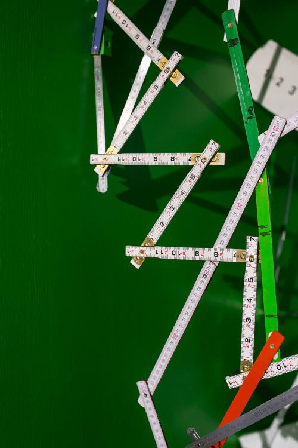 Extandable wooden ruler on a green background Extandable wooden ruler on a green background