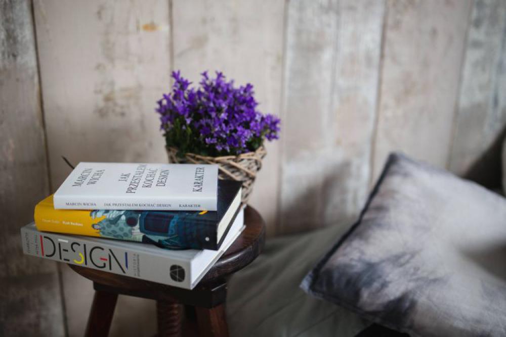 Books and purple flowers on a wooden stool by the bed Books and purple flowers on a wooden stool by the bed
