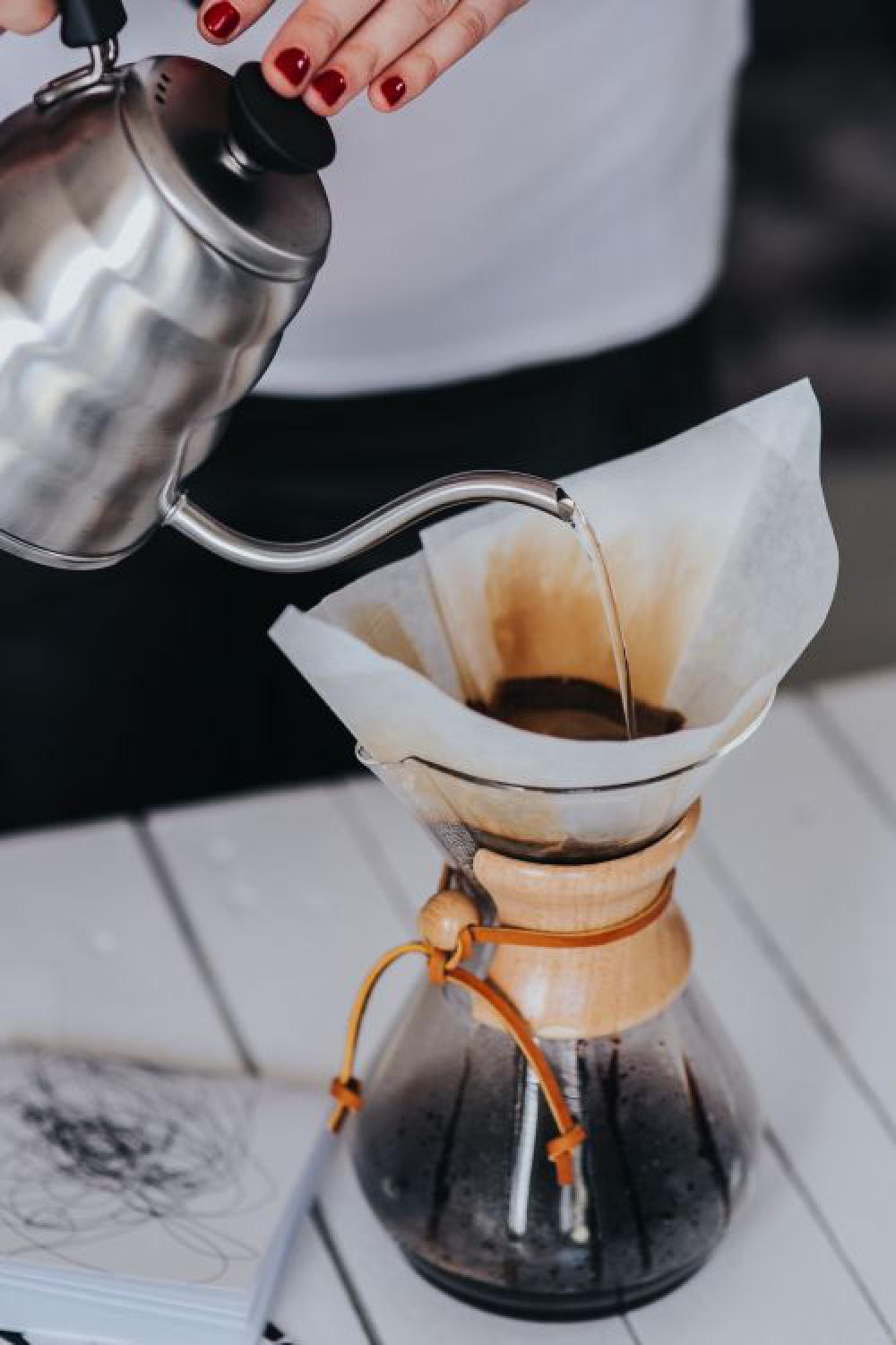 Woman pouring water in Chemex filter coffee maker Woman pouring water in Chemex filter coffee maker