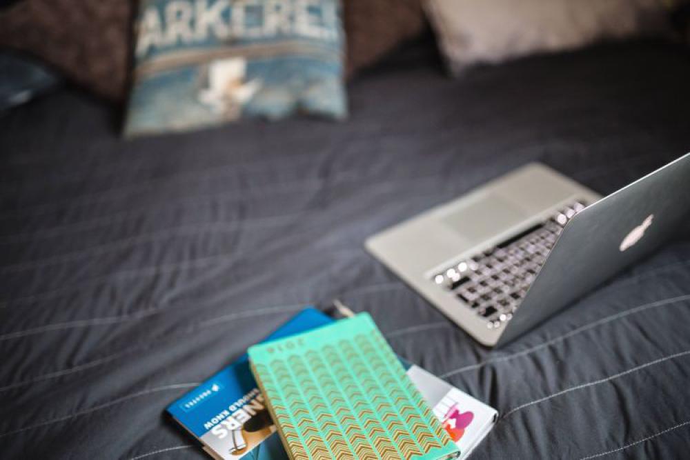 Laptop with books on a bed Laptop with books on a bed