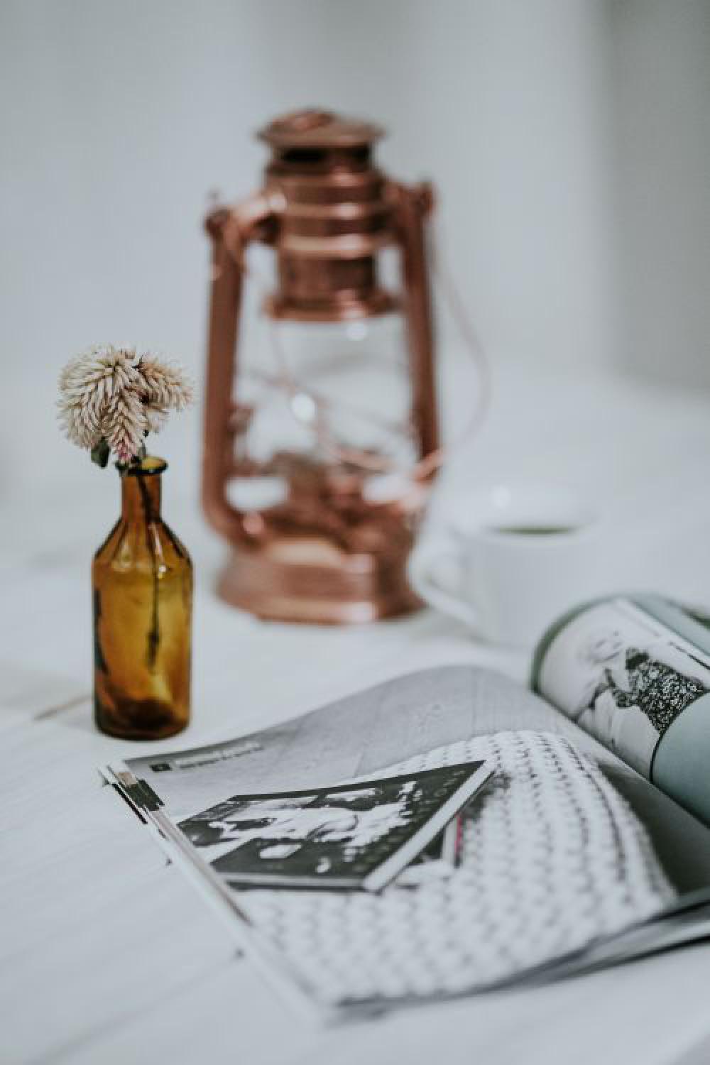 Magazine with a paraffin lamp on a white table Magazine with a paraffin lamp on a white table