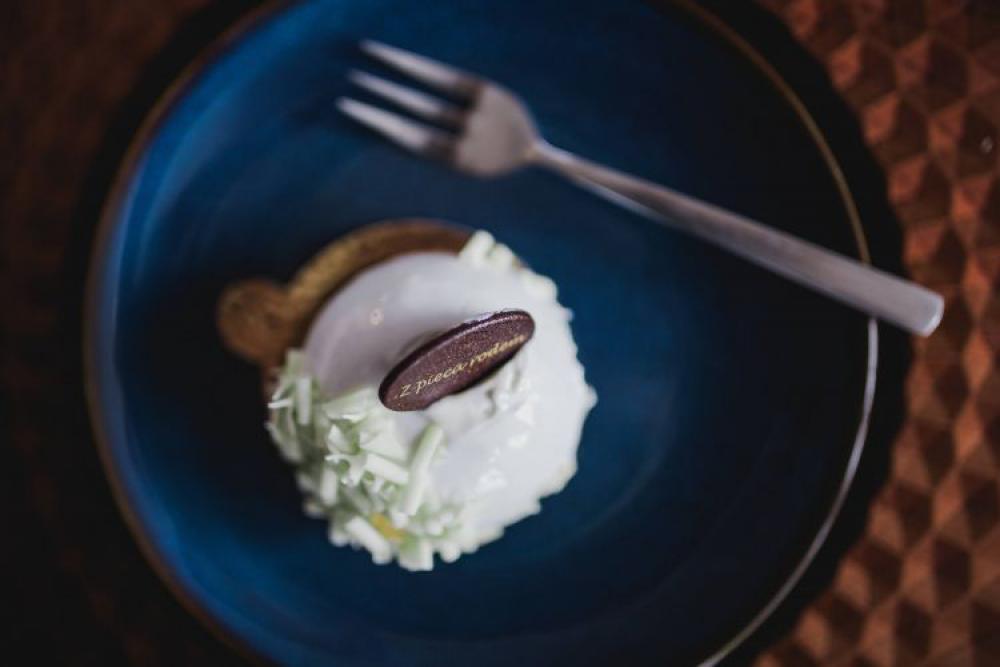 Sweet little white chocolate dessert on a blue saucer in a cake shop Sweet little white chocolate dessert on a blue saucer in a cake shop