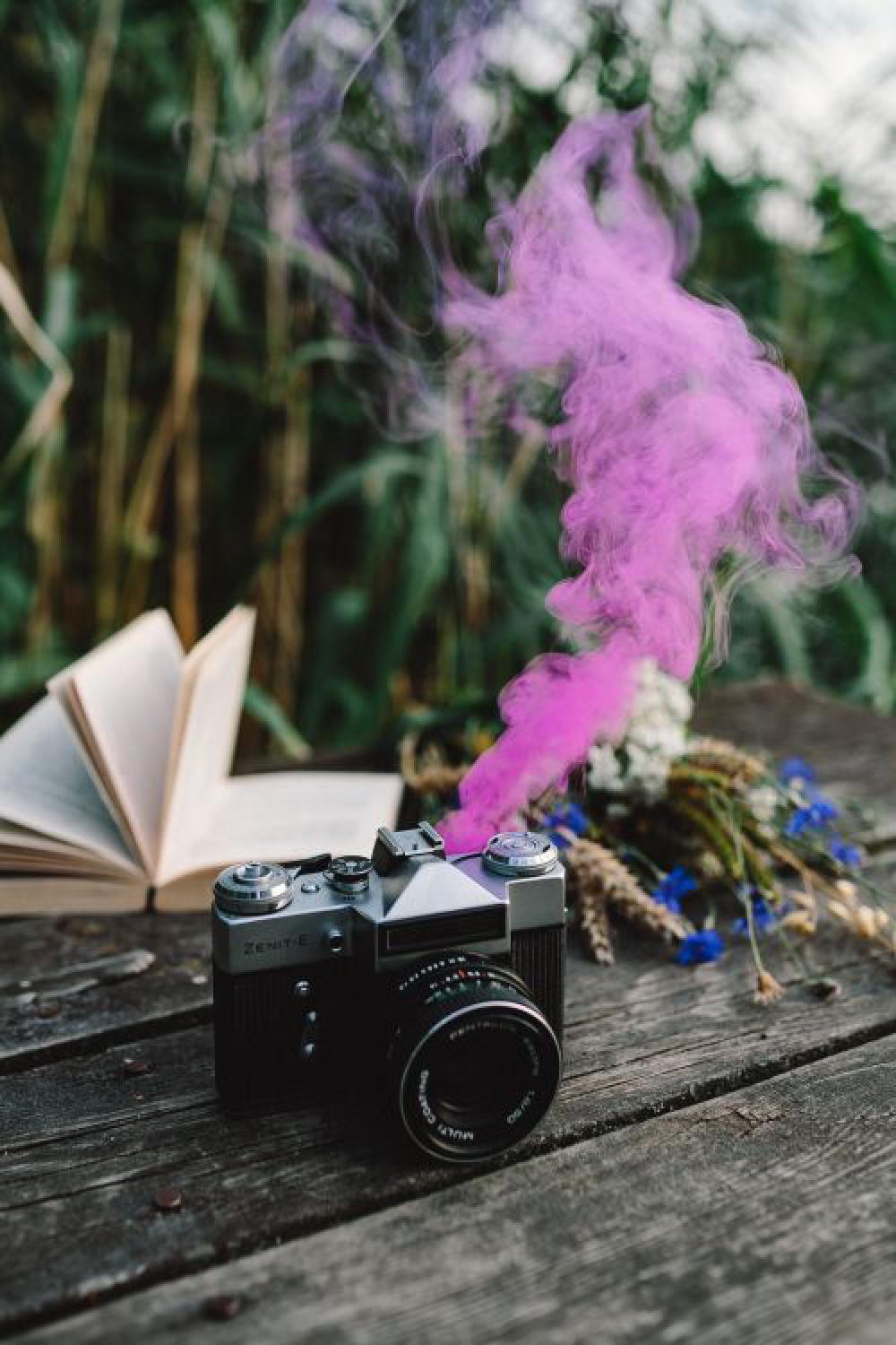 Colorful smoke bomb, book and vintage camera Colorful smoke bomb, book and vintage camera