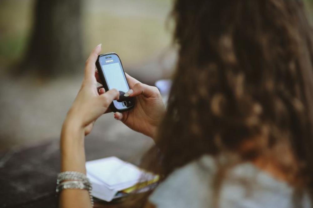 Young woman holding the white mobile phone Young woman holding the white mobile phone