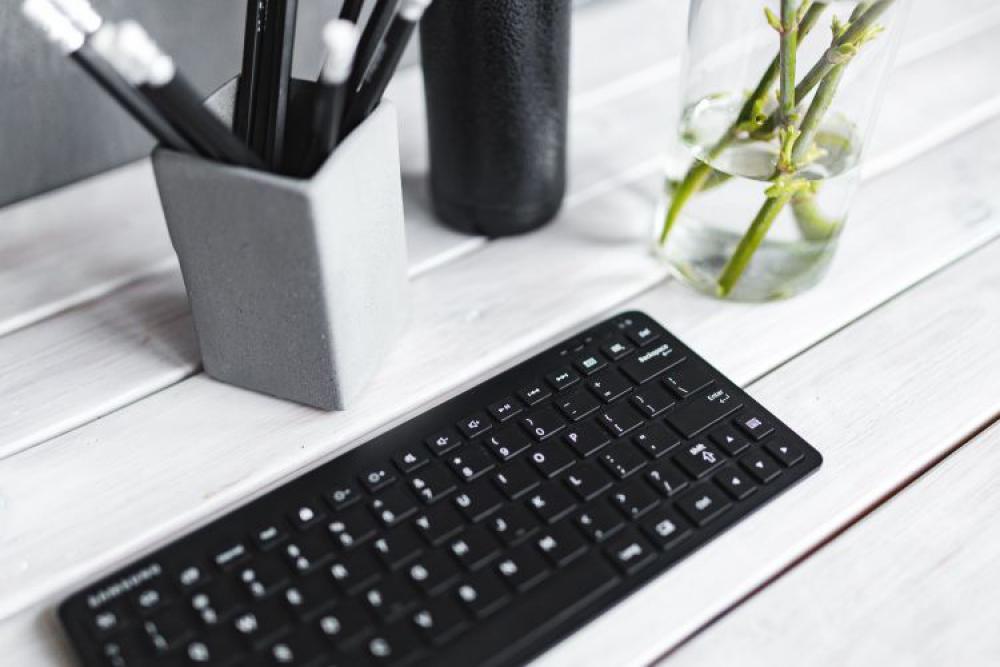 Black keyboard with pencils on a white table Black keyboard with pencils on a white table