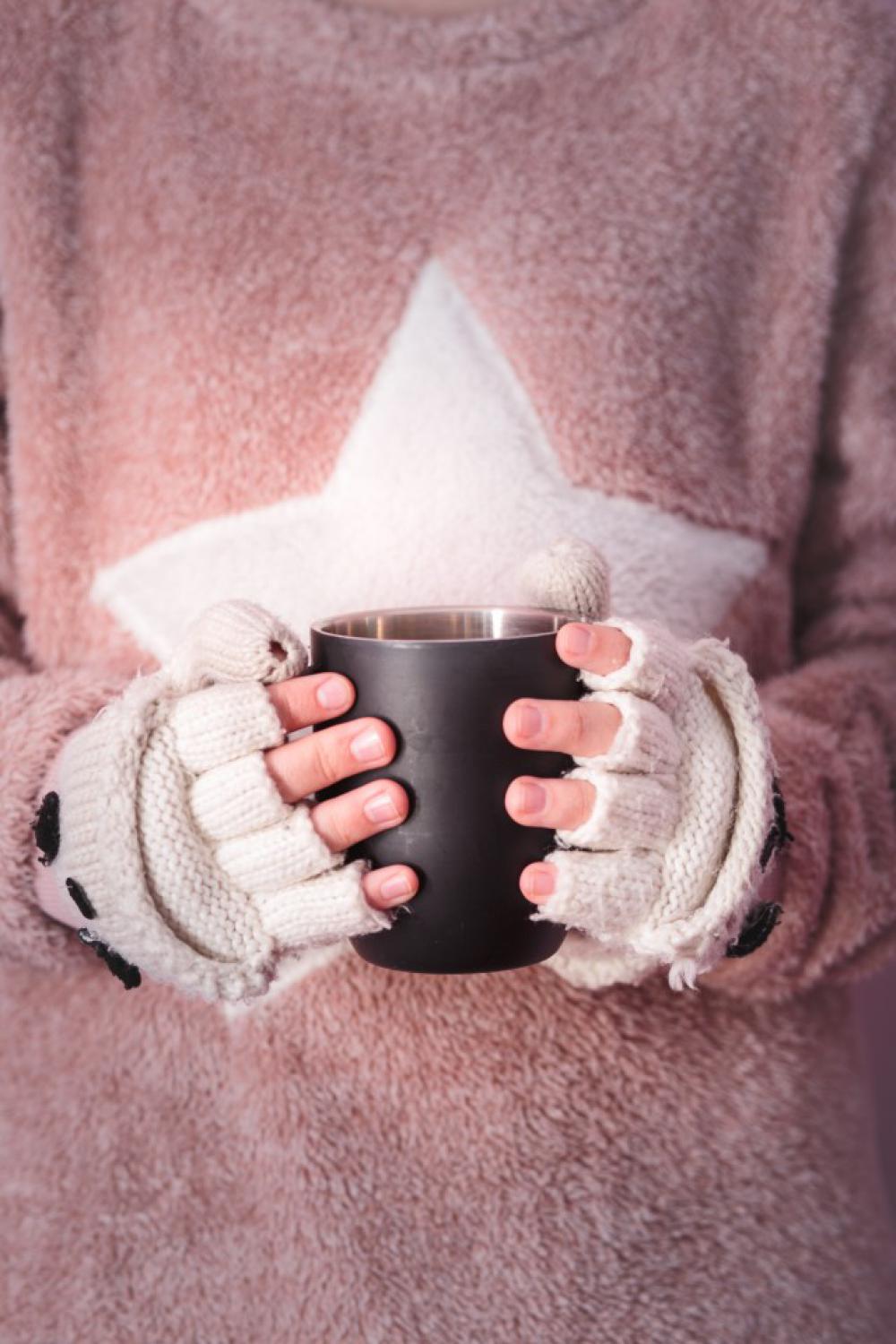 Female hands holding mug with hot drink Female hands holding mug with hot drink
