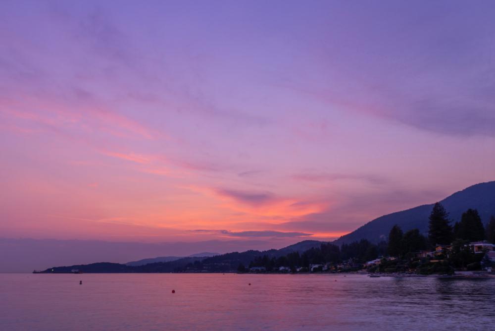 Purple Sunset Reflects Off Calm Coastal Waters Photo Purple Sunset Reflects Off Calm Coastal Waters Photo