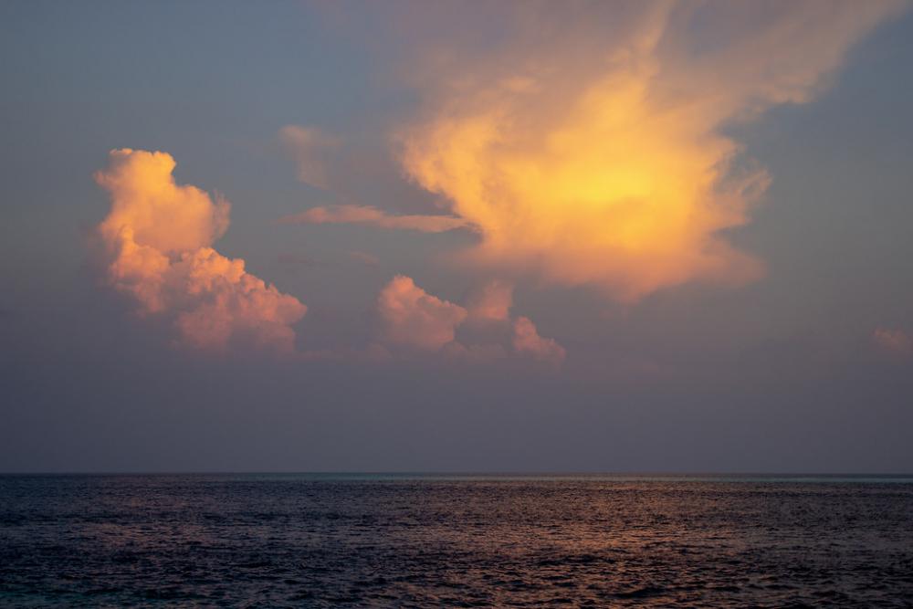 Two Orange Clouds Over the Sea at Sunset Two Orange Clouds Over the Sea at Sunset
