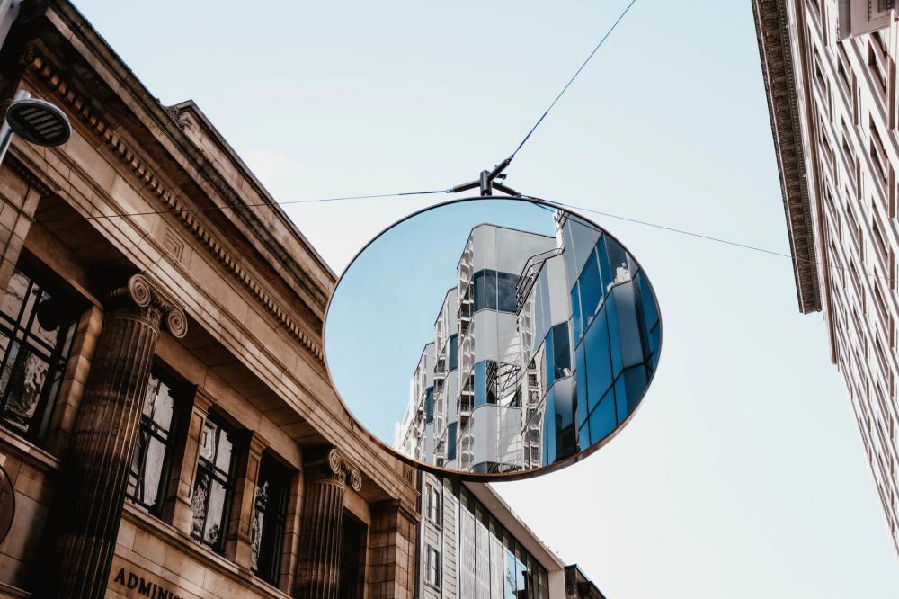 A White Building Is Reflected In A Large Traffic Mirror Photo A White Building Is Reflected In A Large Traffic Mirror Photo