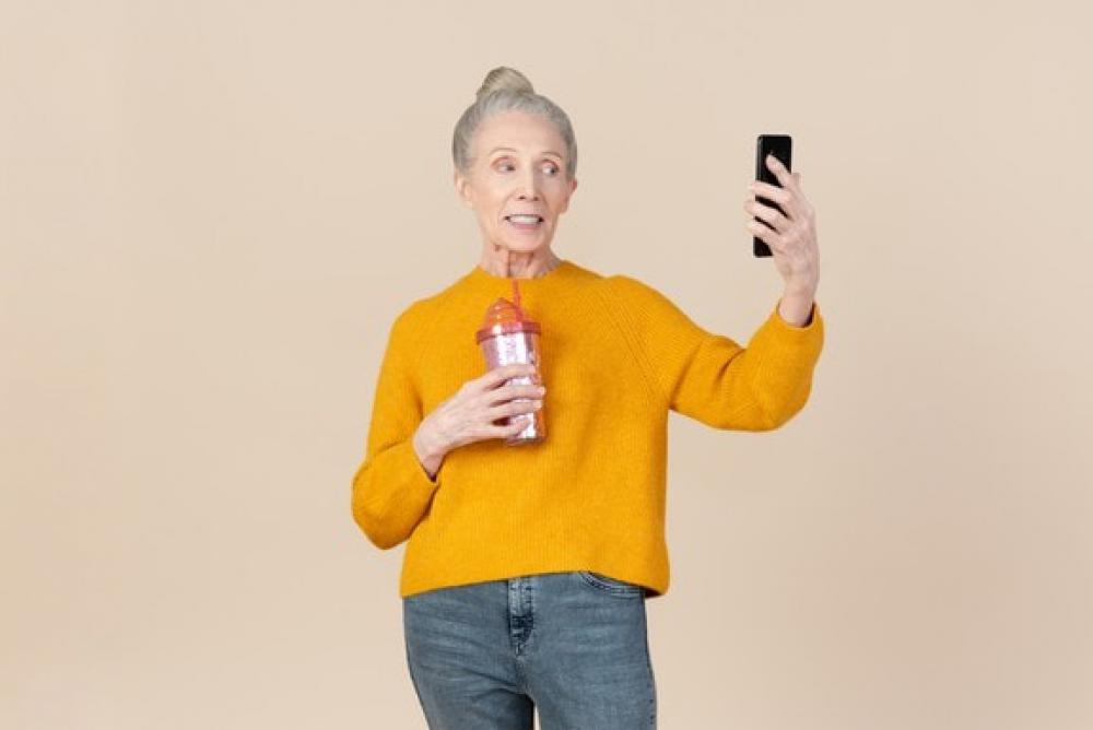 Old Woman Holding Plastic Cup To Go And Making Selfie Old Woman Holding Plastic Cup To Go And Making Selfie
