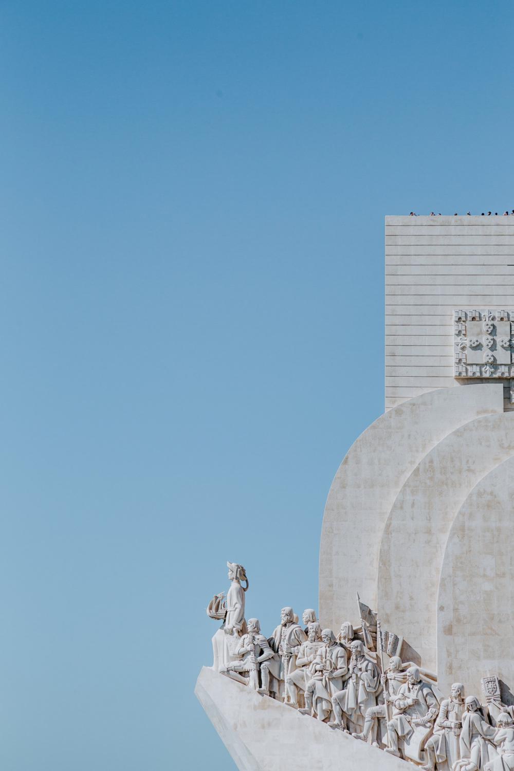 Carved Marble Statues Perched Atop Building Photo Carved Marble Statues Perched Atop Building Photo