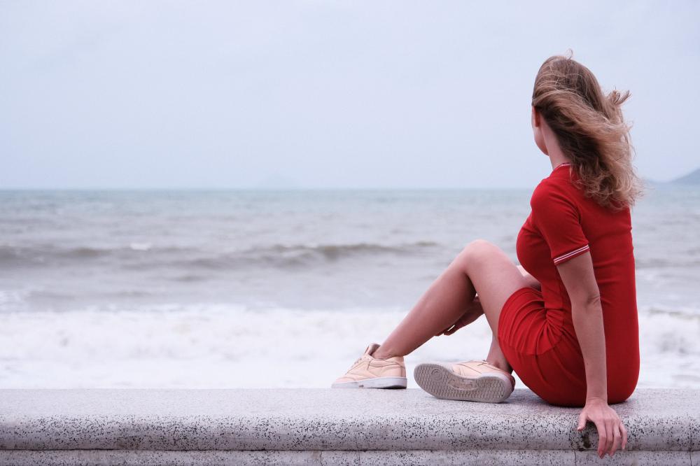 Woman Sits On Seawall Photo Woman Sits On Seawall Photo