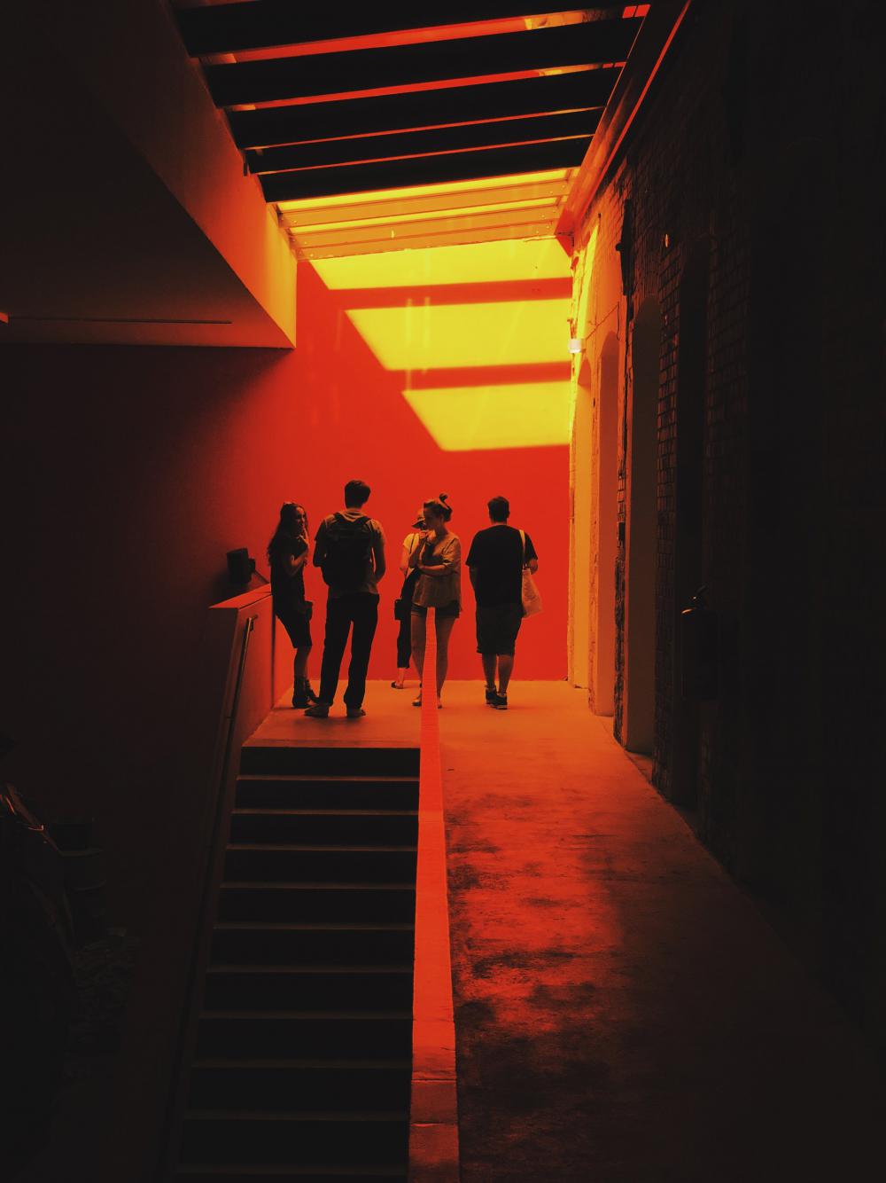 A Group Of People Stand Surrounded By A Red Glow Photo A Group Of People Stand Surrounded By A Red Glow Photo
