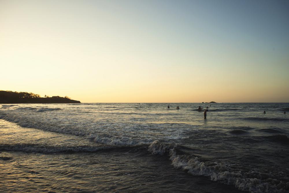 Sun Sets Over Surfers And Beach Goers Photo Sun Sets Over Surfers And Beach Goers Photo