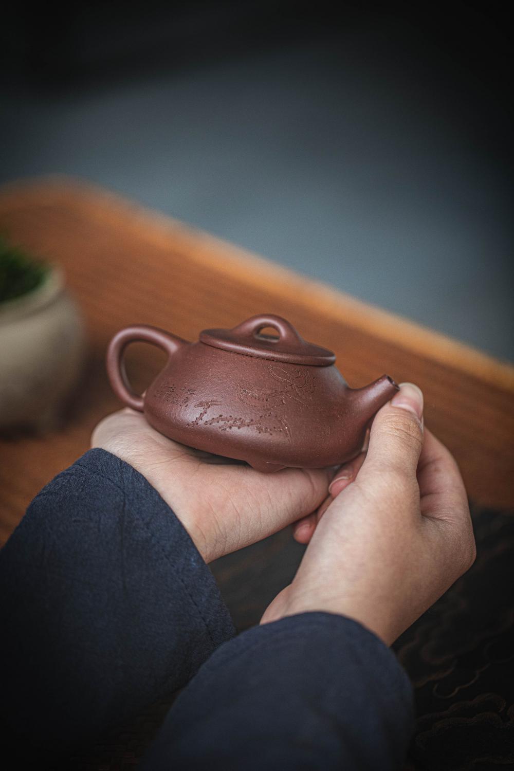 Hands Holding A Carved Chinese Teapot Photo Hands Holding A Carved Chinese Teapot Photo