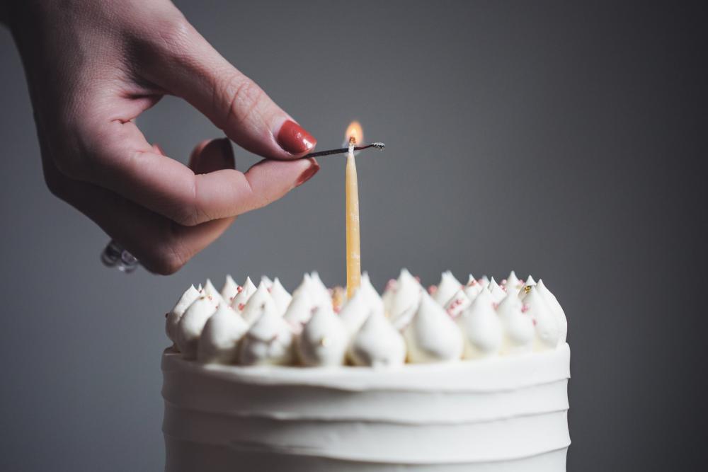 A Woman Lits A Single Birthday Candle Photo A Woman Lits A Single Birthday Candle Photo