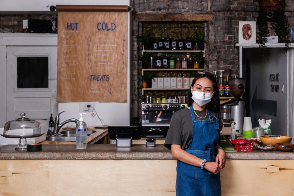 Young Woman Wearing Face Mask In Store Photo Young Woman Wearing Face Mask In Store Photo