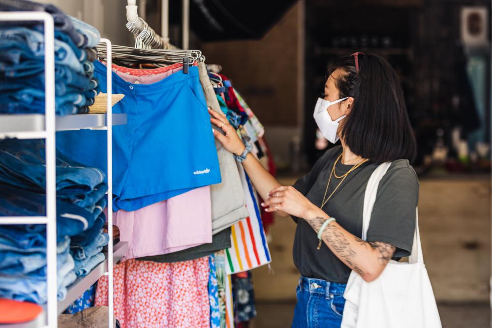 Shopper Browses Clothes Store In Face Mask Photo Shopper Browses Clothes Store In Face Mask Photo