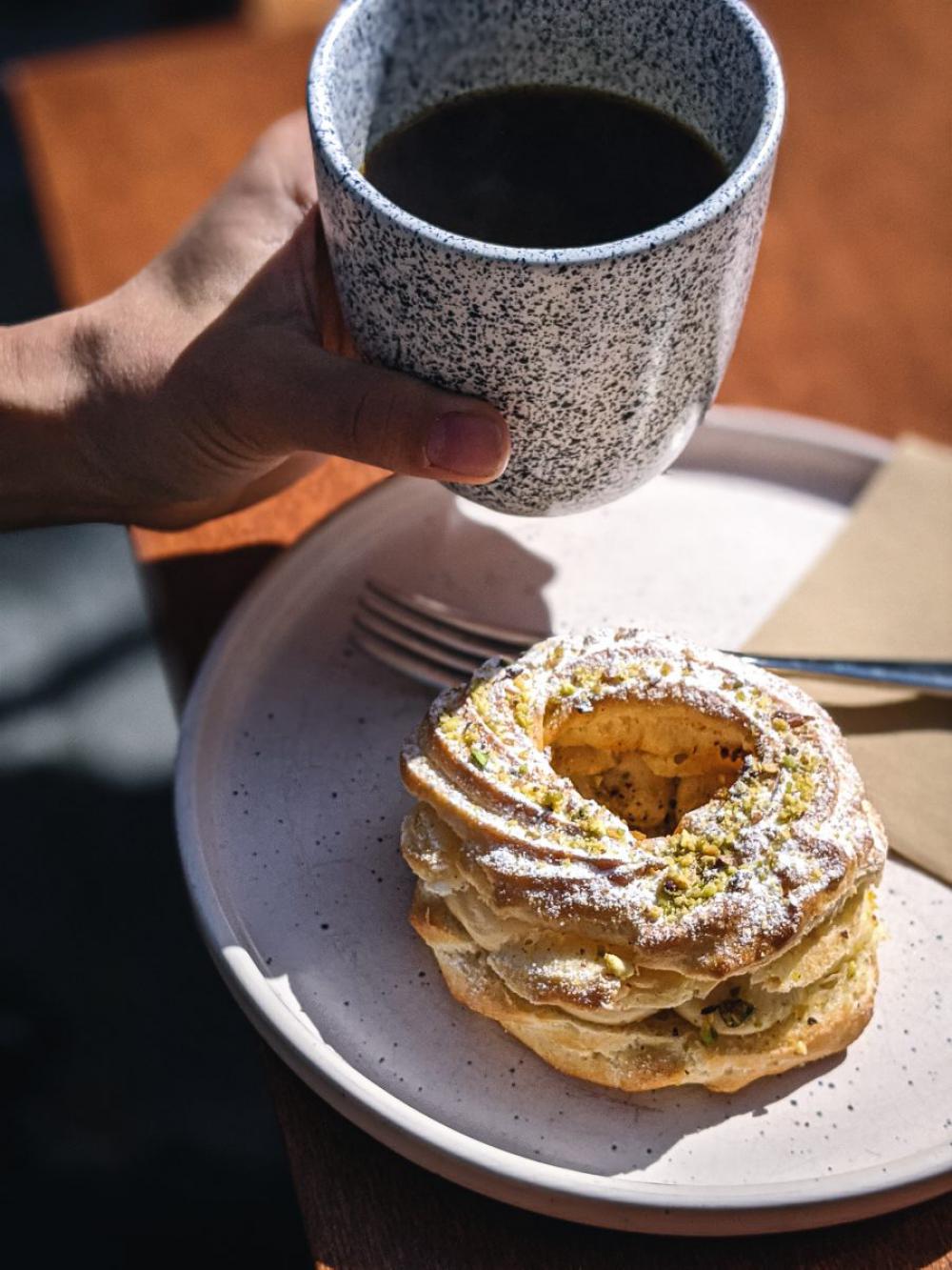 Girl having filtered coffee with puffed dessert Girl having filtered coffee with puffed dessert