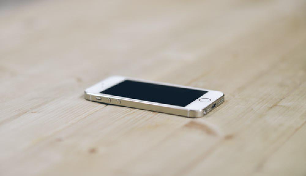 White iPhone 5s On clean Wooden Desk White iPhone 5s On clean Wooden Desk