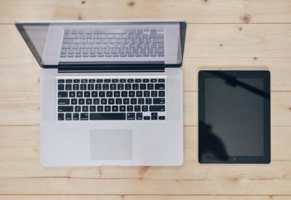 Open Laptop With Ipad On Wooden Desk Open Laptop With Ipad On Wooden Desk