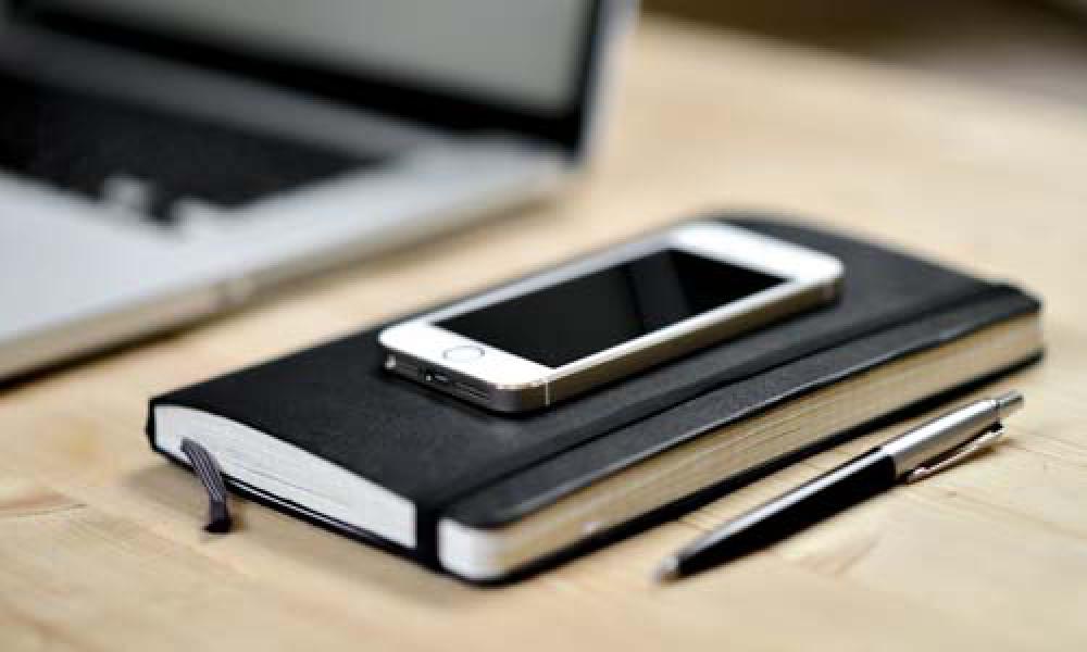 Smart Phone, Notebook, Pen and Open Laptop On Desk Smart Phone, Notebook, Pen and Open Laptop On Desk