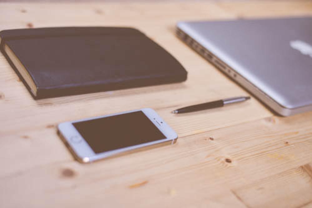 Book, Pan, Smartphone And Laptop On Wooden Office Desk Book, Pan, Smartphone And Laptop On Wooden Office Desk