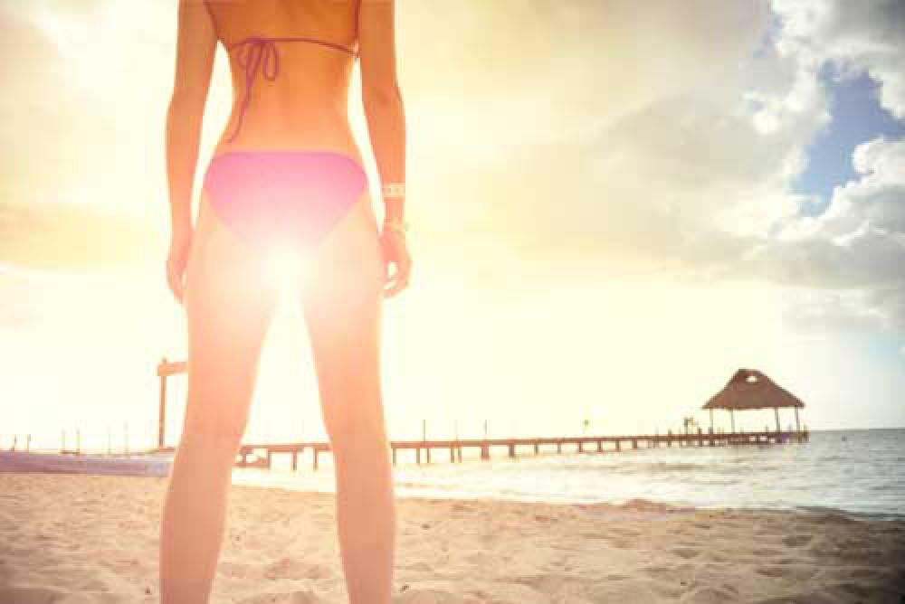 Woman Wearing Bikini On Beach With Sun Flare Between Legs Woman Wearing Bikini On Beach With Sun Flare Between Legs