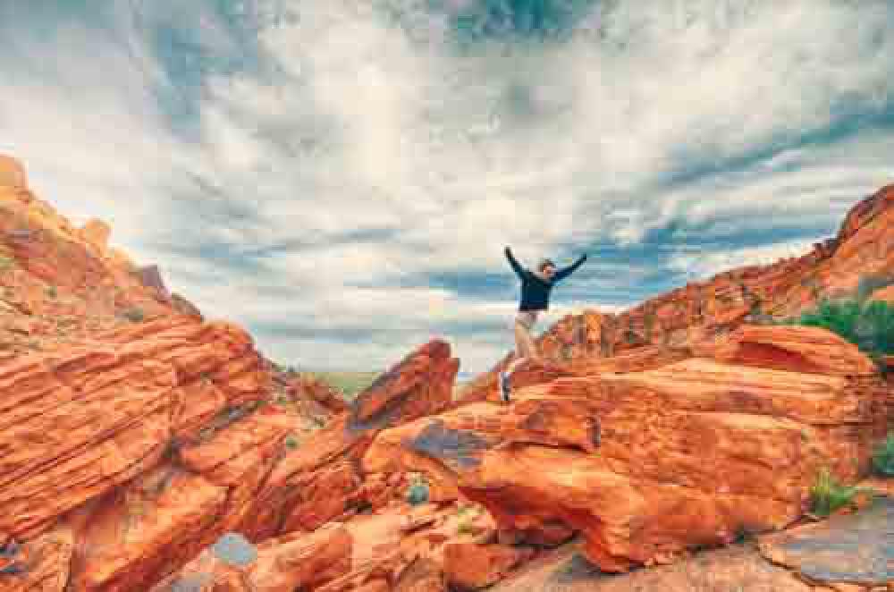 Girl Playfully Jumping Between Rocks While Hiking Girl Playfully Jumping Between Rocks While Hiking