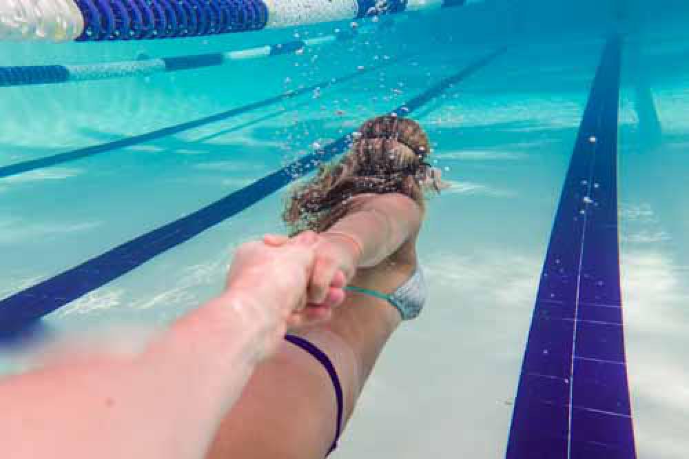 Girl Holding Mans Hand Whilst Swimming Underwater Girl Holding Mans Hand Whilst Swimming Underwater