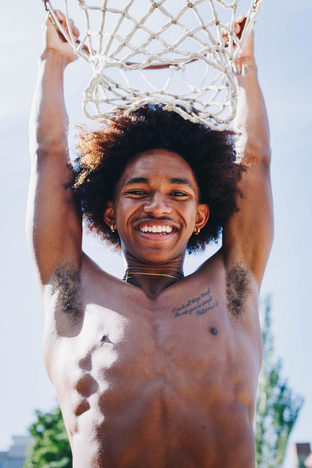 Young Man Hangs From Basketball Net Photo Young Man Hangs From Basketball Net Photo