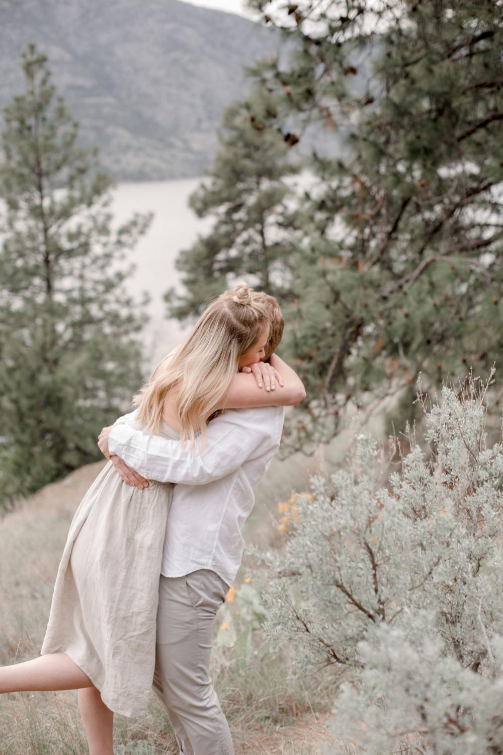 A Couple Embrace On A Mountain Side Photo A Couple Embrace On A Mountain Side Photo