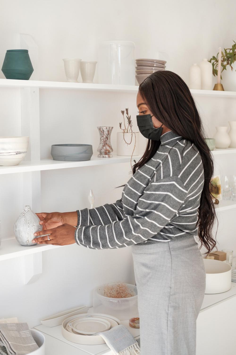 Woman In Face Mask Picks Up A Product Photo Woman In Face Mask Picks Up A Product Photo