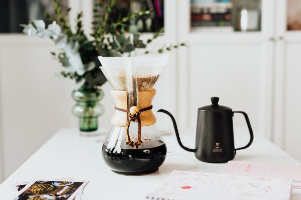 The woman drinks coffee and works at her desk The woman drinks coffee and works at her desk