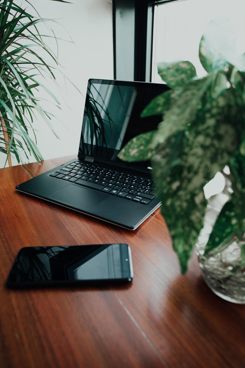 Open Laptop and Cell Phone On Table Photo Open Laptop and Cell Phone On Table Photo