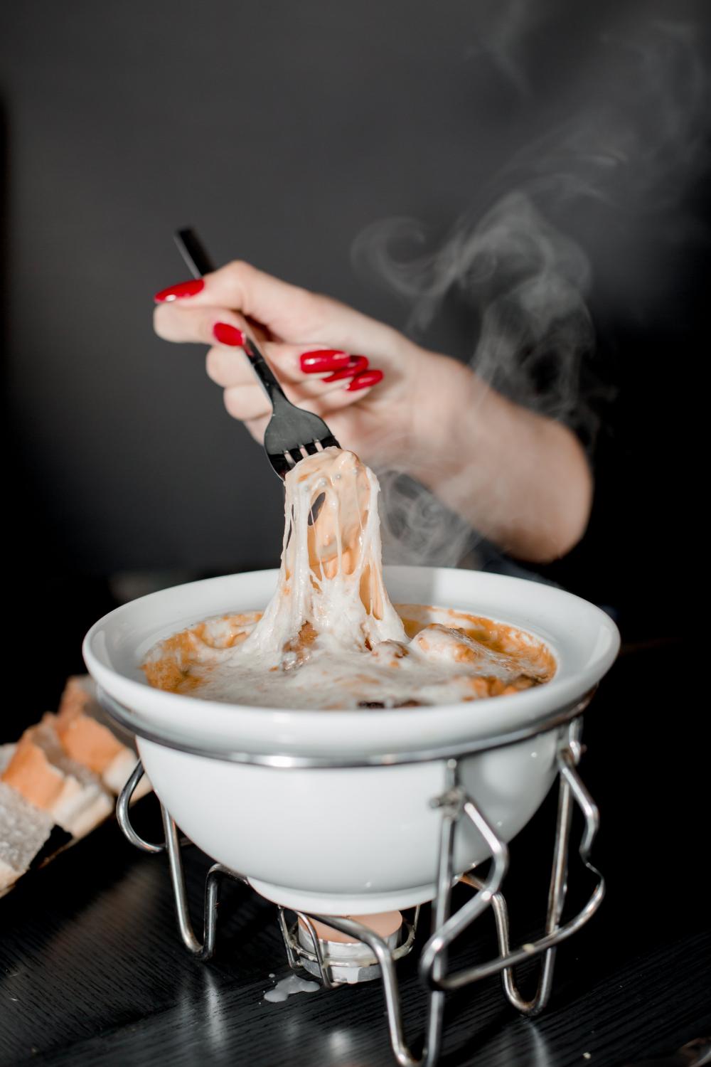 A Person Enjoys Cheesey Fondue Photo A Person Enjoys Cheesey Fondue Photo